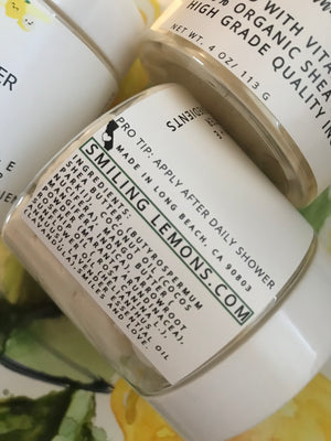 Smiling Lemons Whipped Body Butter in  recyclable  jars.  White label on jar with the logo Smiling Lemons on the top  and displays label that shows all organic ingredients found in product.  